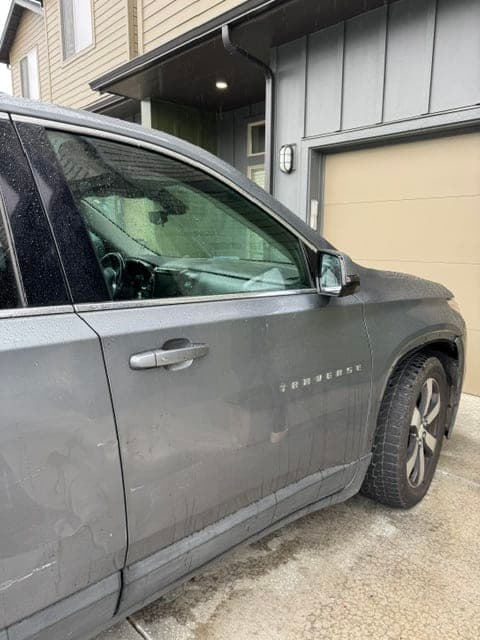 Gray Chevrolet Traverse front door glass and side mirror after auto glass service