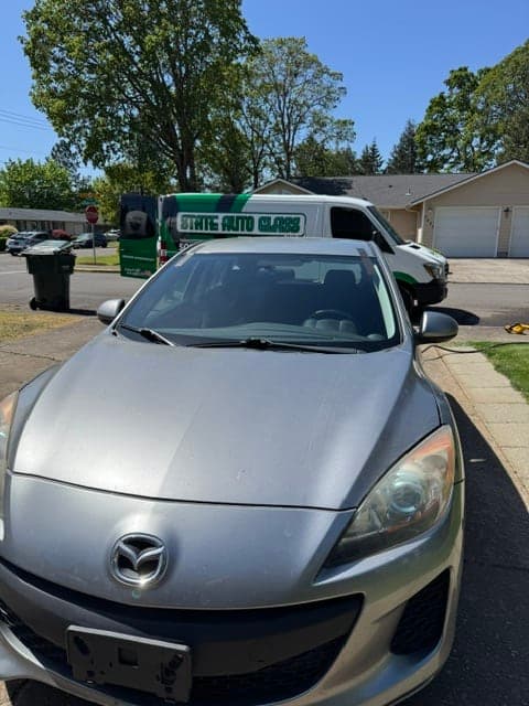 State Auto Glass branded service van behind a silver Mazda after mobile windshield service
