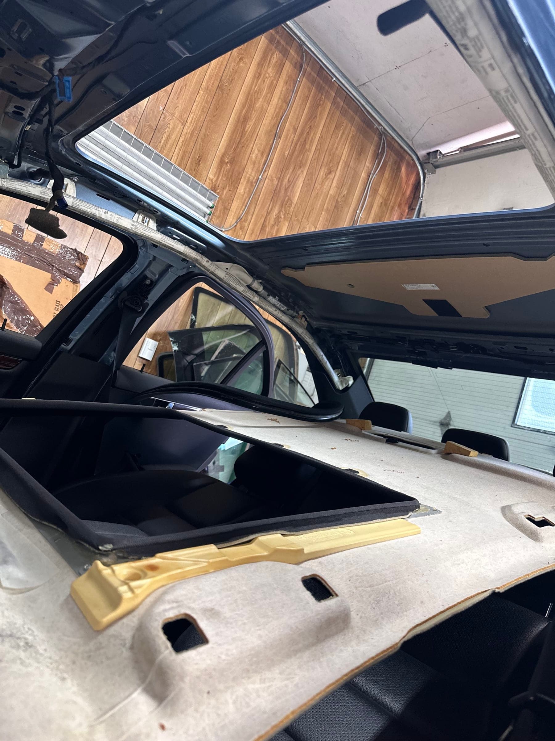 Complete glass sunroof assembly removed from a vehicle on a service stand